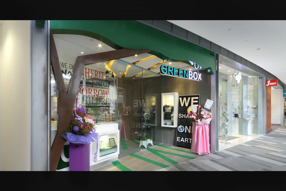 A stylised tree branch runs across the shopfront glazing, tying the store's eco-conscious branding into its physical design.