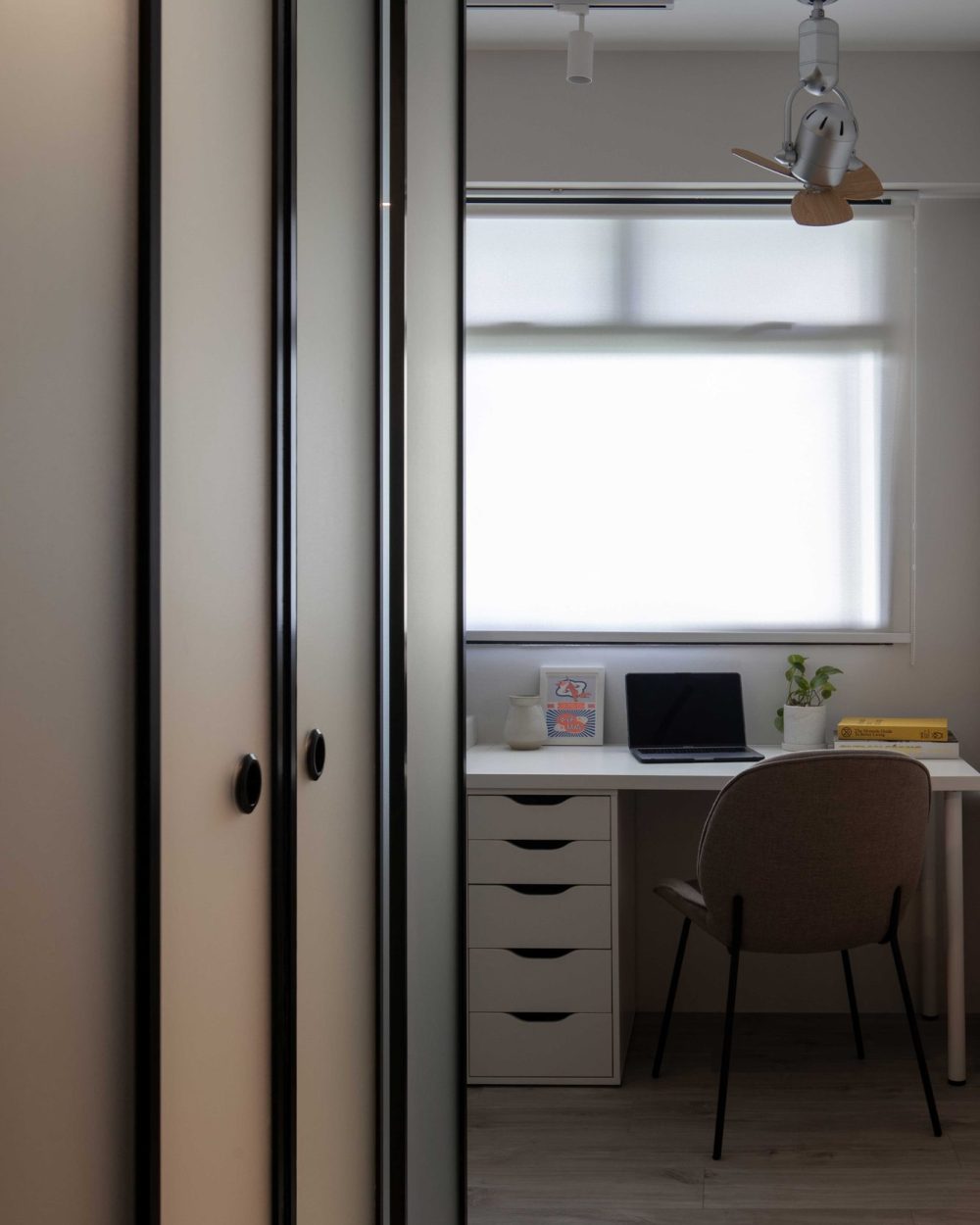 A frosted glass sliding door reveals a walk-in wardrobe, with a built-in study desk visible in the room beyond.