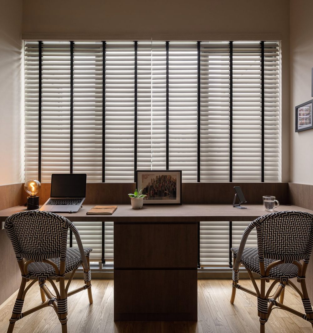 Brass initial pulls personalise the wardrobe doors lining this corridor, which opens onto a second desk area.