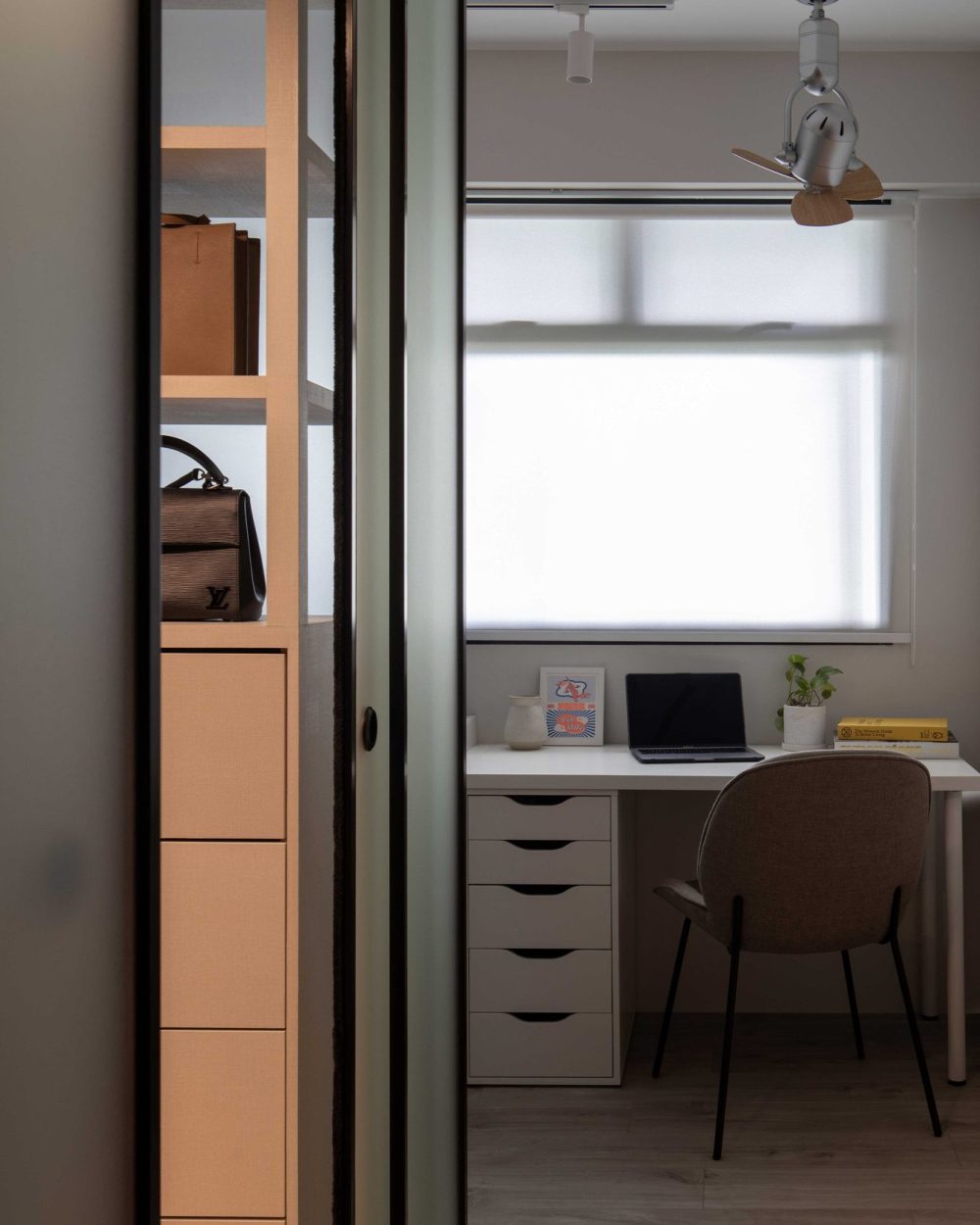 Open shelving within the wardrobe keeps handbags and accessories on display, glimpsed through the frosted glass sliding door.