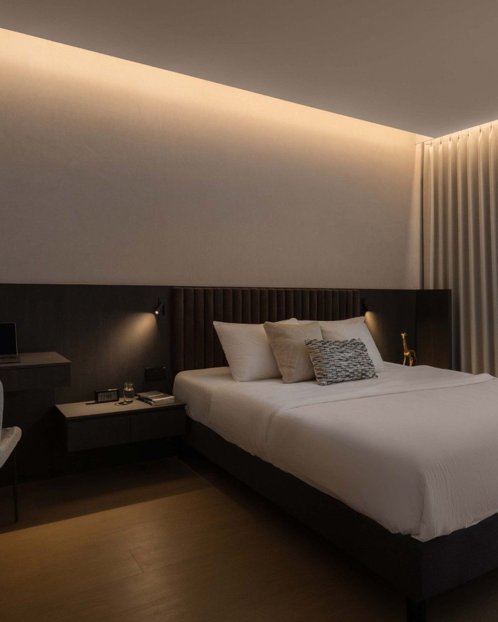 The full bedroom layout pairs the built-in study desk with the upholstered bed and floor-length curtains, keeping work and rest within the same warm,
