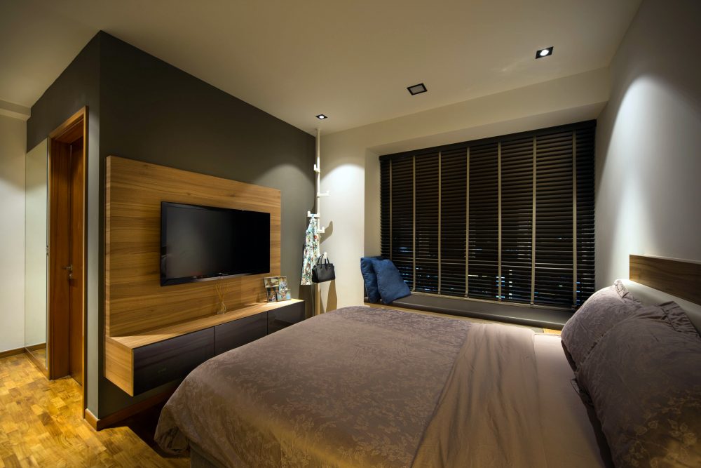 Timber panelling wraps the TV wall in the bedroom, paired with black venetian blinds for a warm, hotel-like feel.