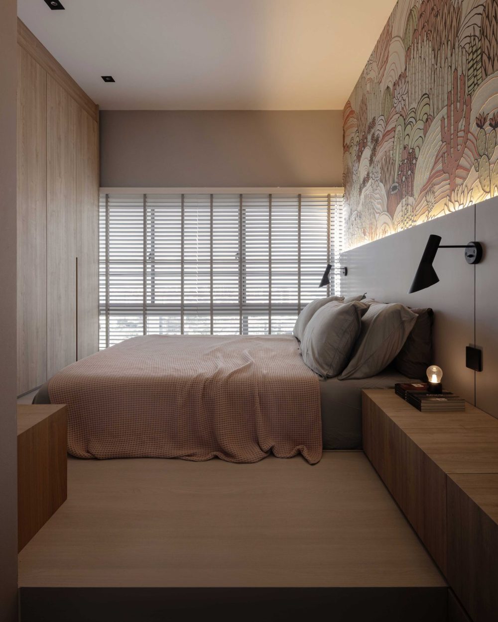 Timber wardrobes and venetian blinds continue the bedroom's warm palette, with a floating nightstand tucked beside the statement wallpaper.