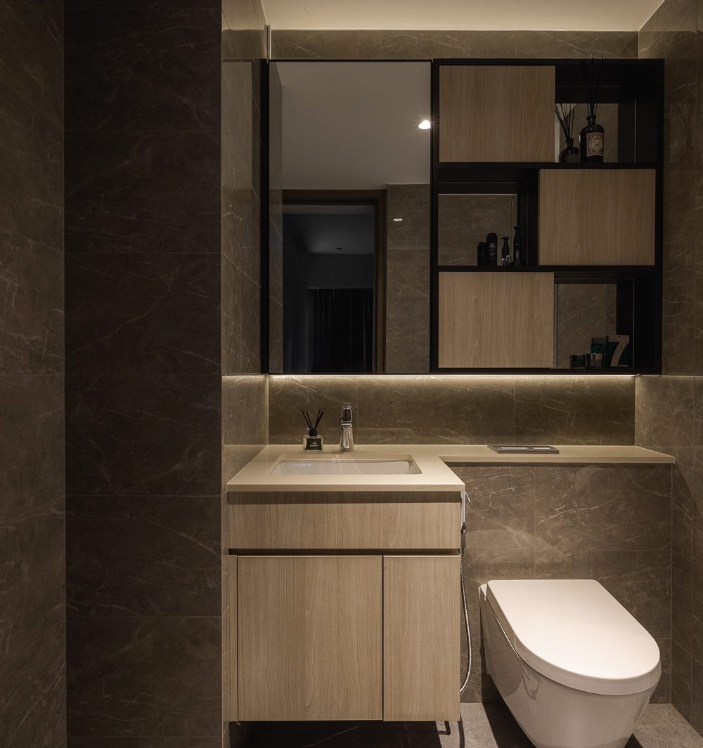 A wall-mounted cabinet with glass shelving and integrated lighting sits above the vanity, keeping toiletries organised and on display.